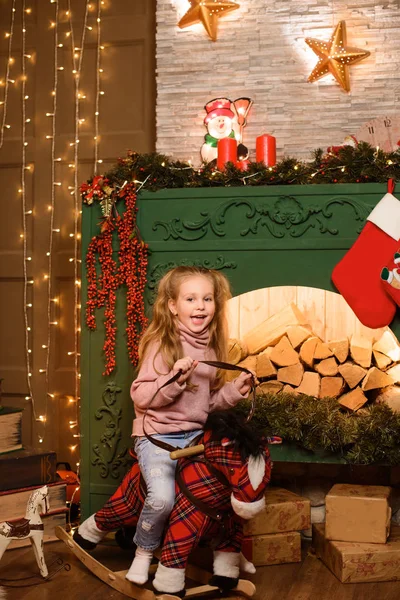 Flicka Ridning Toy Horse Nära Festlig Jul Eldstad — Stockfoto