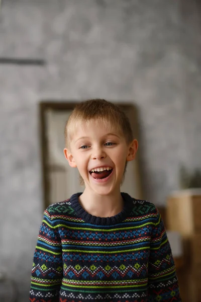 笑着的可爱的金发男孩的画像 穿着毛衣 房间里有灰色的墙壁 — 图库照片
