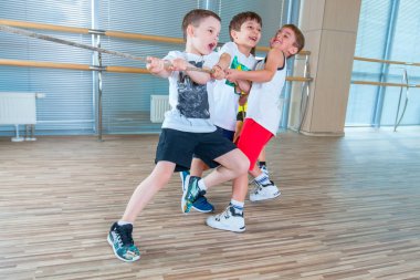 Çocuk ve Rekreasyon, grup mutlu çok ırklı okulun spor salonunda halat çekme halatı ile oynayan çocuklar
