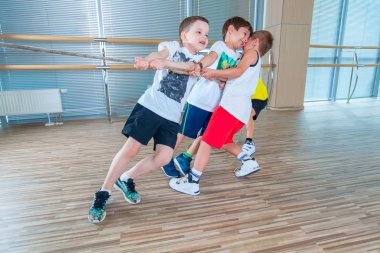 Çocuk ve Rekreasyon, grup mutlu çok ırklı okulun spor salonunda halat çekme halatı ile oynayan çocuklar.