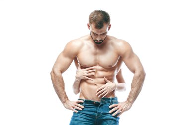 vücut geliştirmeci poz. Güzel sportif adam erkek güç. Fitness mavi kot pantolon kaslı. izole beyaz arka plan üzerinde. kadın kucaklama küpleri basın eller. ABS