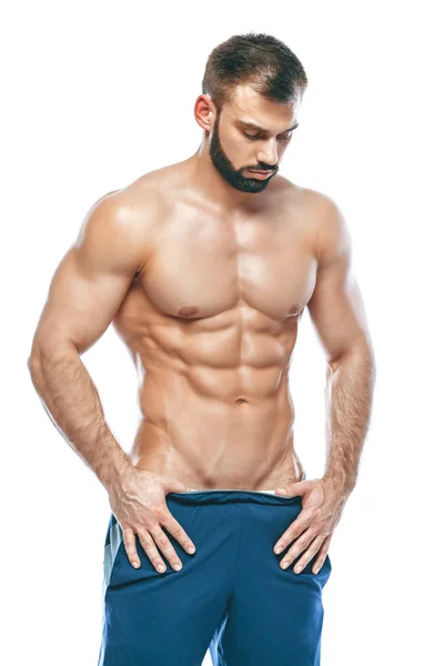 Fisiculturista posando. Bonito desportista poder masculino. Fitness musculado em calções azuis. sobre fundo branco isolado. Homem com tronco musculado. Forte Homem Atlético Fitness Modelo Torso mostrando seis pack abs — Fotografia de Stock