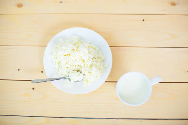 Hüttenkäse en melk close-up op een houten tafel. — Stockfoto