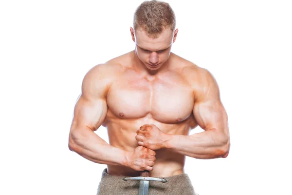 Bodybuilder man poseren met een zwaard geïsoleerd op een witte achtergrond. Ernstige shirtless man aan te tonen zijn lichaam mascular. — Stockfoto