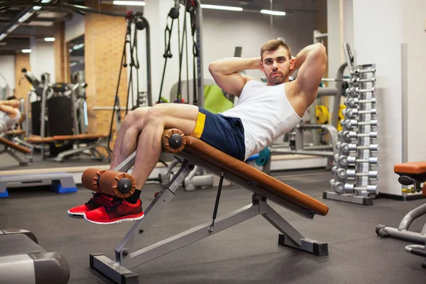 Esporte, fitness, musculação, estilo de vida e conceito de pessoas - jovem fazendo sentar-se exercícios abdominais Bench Press no ginásio — Fotografia de Stock