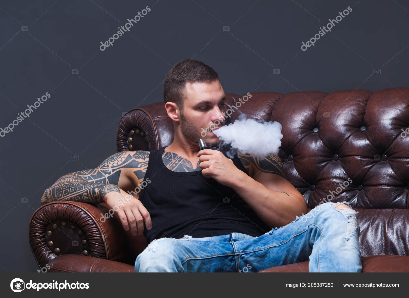Vaper The Man With Sits On A Leather Sofa Smoke An