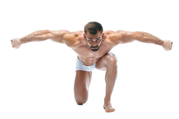 Kroppsbyggare poserar. Vacker sportig kille manlig makt. Konditionen muskulös manin vita underkläder. på isolerade vit bakgrund. knäböjer — Stockfoto
