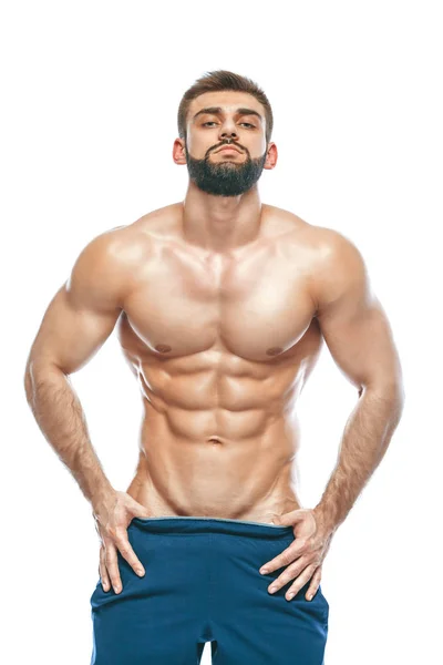 Fisiculturista posando. Bonito desportista poder masculino. Fitness musculado em calções azuis. sobre fundo branco isolado. Homem com tronco musculado. Forte Homem Atlético Fitness Modelo Torso mostrando seis pack abs — Fotografia de Stock