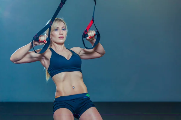 Спортивная женщина делает TRX упражнения в тренажерном зале — стоковое фото