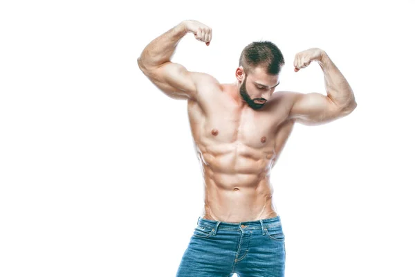 Bodybuilder poseren. Mooie sportieve vent mannelijke kracht. Fitness gespierd in spijkerbroek. op geïsoleerde witte achtergrond. — Stockfoto