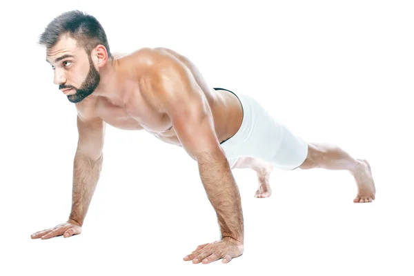Armhävningar. kroppsbyggare poserar. Vacker sportig kille manlig makt. Konditionen muskulös manin vita underkläder. på isolerade vit bakgrund. — Stockfoto