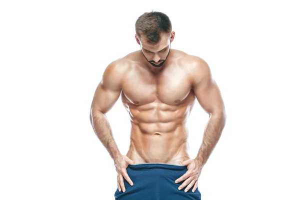 Bodybuilder που παρουσιάζουν. Όμορφη Αθλητικός τύπος ανδρική εξουσία. Γυμναστήριο μυώδης σε μπλε σορτς. σε απομονωμένες άσπρο φόντο. Άνθρωπος με μυϊκή κορμό. Ισχυρή αθλητικό κορμό μοντέλο Fitness άνθρωπος δείχνει abs έξι πακέτων — Φωτογραφία Αρχείου