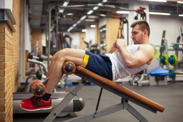 Esporte, fitness, musculação, estilo de vida e conceito de pessoas - jovem fazendo sentar-se exercícios abdominais Bench Press no ginásio — Fotografia de Stock