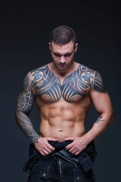 Людина з м'язової голий частину тулуба з тату на темному тлі. ABS — стокове фото