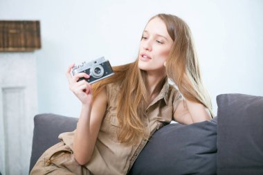 Güzel genç sarışın bir kadın ile bir fotoğraf makinesi portre yaşam tarzı.