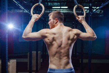 Kaslı adam Yüzüklerin stil uygun çapraz üzerinde egzersiz yaparak