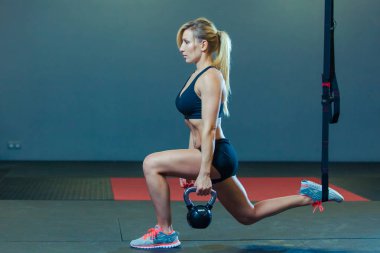 Sportif kadın spor salonunda TRX ve ağırlık egzersizleri yapıyor