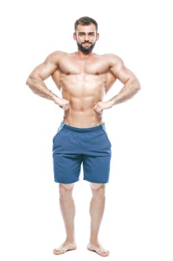 vücut geliştirmeci poz. Güzel sportif adam erkek güç. Fitness mavi şort kaslı. izole beyaz arka plan üzerinde. Kas gövde olan adam. Güçlü atletik erkek Fitness modeli gövde gösteren altı bohça abs