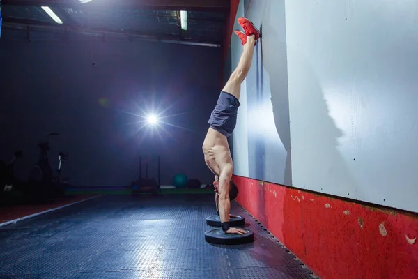 Foto de un joven en forma haciendo un ejercicio de soporte de mano en un ajuste estilo Cruz . — Foto de Stock