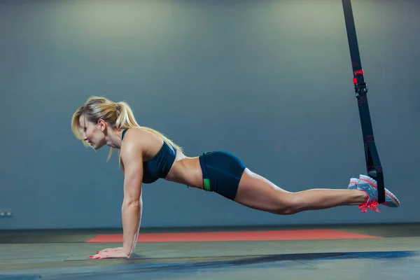 Mulher desportiva fazendo exercícios TRX no ginásio — Fotografia de Stock