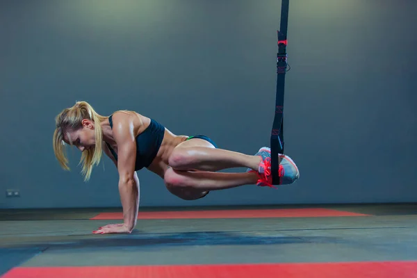 Mulher desportiva fazendo exercícios TRX no ginásio — Fotografia de Stock