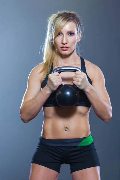 Passen vrouw doen squats met kettlebell in sportclub. sportschool — Stockfoto