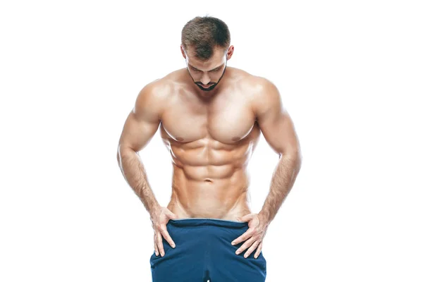 Bodybuilder poseren. Mooie sportieve vent mannelijke kracht. Fitness gespierd in blauwe shorts. op geïsoleerde witte achtergrond. Man met gespierde torso. Sterke atletische Man Fitness Model Torso weergegeven: zes pack abs — Stockfoto