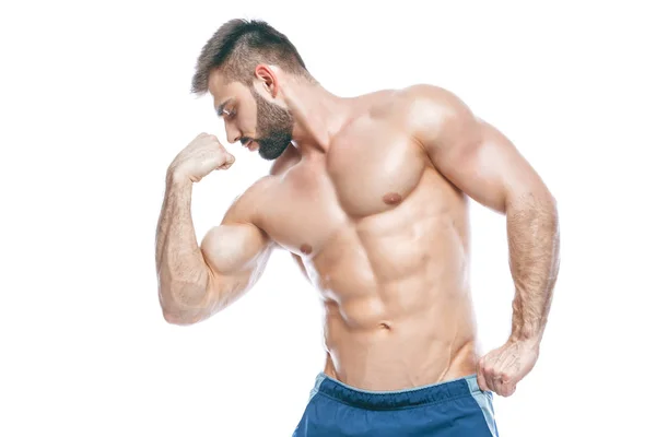 Culturista posando. Hermoso chico deportivo poder masculino. Fitness musculoso en pantalones cortos azules. sobre fondo blanco aislado. Hombre con torso muscular. Torso atlético fuerte del modelo de la aptitud del hombre que muestra seis abs del paquete — Foto de Stock