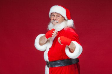 Noel. Noel Baba kırmızı bandaj boks için ellerinde yara ile başladı taklit ediyor. Kickboks, karate, boks. Kırmızı zemin üzerine izole.