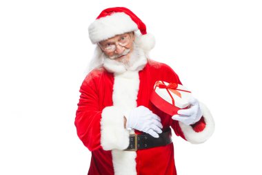 Noel. Noel Baba beyaz eldiven gülümseyen bir kırmızı ve beyaz kalp şeklinde hediye kutu kırmızı kurdele ile tutar. Beyaz arka plan üzerinde izole.