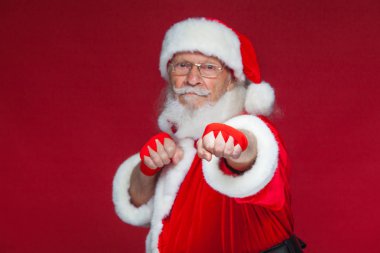 Noel. Noel Baba kırmızı bandaj boks için ellerinde yara ile başladı taklit ediyor. Kickboks, karate, boks. Kırmızı zemin üzerine izole.