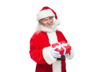 Noel. Noel Baba beyaz eldiven gülümseyen bir hediye kırmızı kutusu bir yay ile tutuyor. Hediyesine işaret. Beyaz arka plan üzerinde izole.