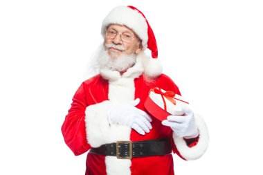 Noel. Noel Baba beyaz eldiven gülümseyen bir kırmızı ve beyaz kalp şeklinde hediye kutu kırmızı kurdele ile tutar. Beyaz arka plan üzerinde izole.