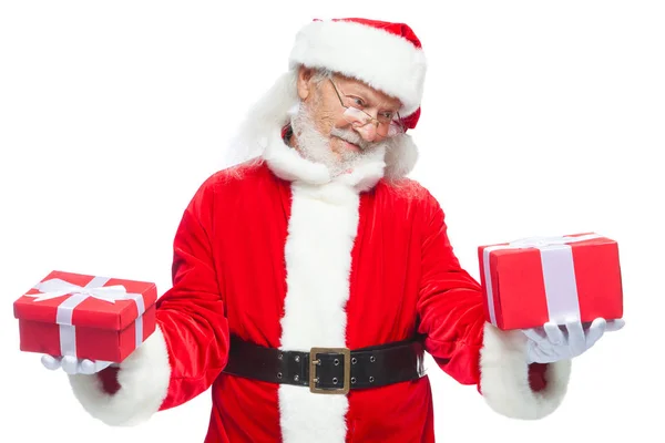 Navidad. Santa Claus sonriente con guantes blancos sostiene dos cajas con regalos. El concepto de elegir un regalo, regalos generosos. Aislado sobre fondo blanco . —  Fotos de Stock