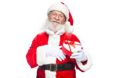 Noel. Noel Baba beyaz eldiven gülümseyen bir kırmızı ve beyaz kalp şeklinde hediye kutu kırmızı kurdele ile tutar. Beyaz arka plan üzerinde izole.