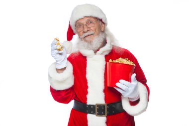 Noel. Gülümsüyor, bir Noel Baba ağız açık beyaz eldiven tek elle, patlamış mısır ile kırmızı bir kova patlamış alır ve ikinci el ile yemek hazırlar tutar. Kavramı