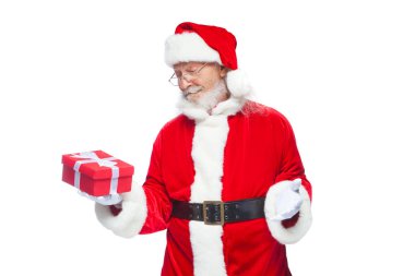 Noel. Noel Baba beyaz eldiven gülümseyen bir hediye kırmızı kutusu bir yay ile tutuyor. Hediyesine işaret. Beyaz arka plan üzerinde izole.
