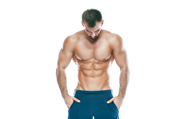 Fisiculturista posando. Bonito desportista poder masculino. Fitness musculado em calções azuis. sobre fundo branco isolado. Homem com tronco musculado. Forte Homem Atlético Fitness Modelo Torso mostrando seis pack abs — Fotografia de Stock