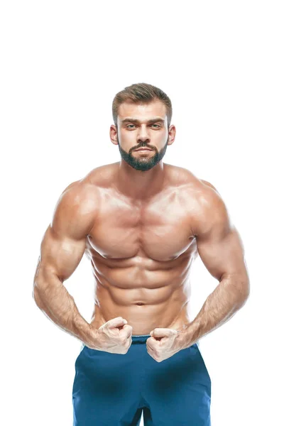 Culturista posando. Hermoso chico deportivo poder masculino. Fitness musculoso en pantalones cortos azules. sobre fondo blanco aislado. Hombre con torso muscular. Torso atlético fuerte del modelo de la aptitud del hombre que muestra seis abs del paquete —  Fotos de Stock