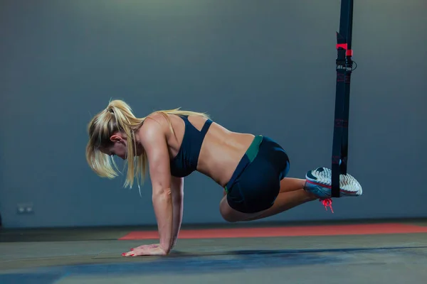 Спортивная женщина делает TRX упражнения в тренажерном зале — стоковое фото