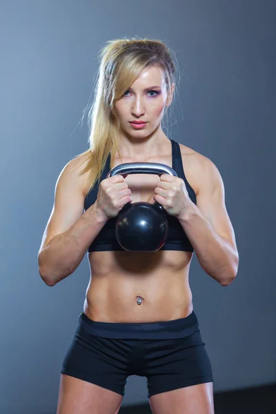 Passen vrouw doen squats met kettlebell in sportclub. sportschool — Stockfoto