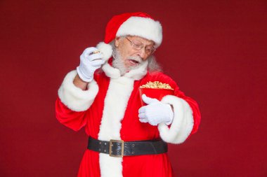 Noel. Gülümsüyor, bir Noel Baba ağız açık beyaz eldiven tek elle, patlamış mısır ile kırmızı bir kova patlamış alır ve ikinci el ile yemek hazırlar tutar. Kavramı