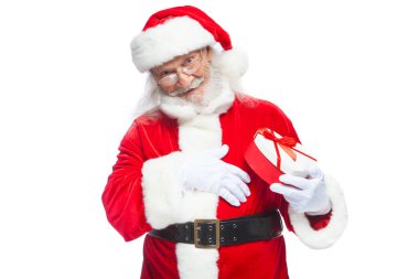 Noel. Noel Baba beyaz eldiven gülümseyen bir kırmızı ve beyaz kalp şeklinde hediye kutu kırmızı kurdele ile tutar. Beyaz arka plan üzerinde izole