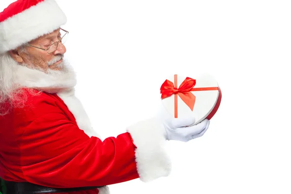 Navidad. Santa Claus en guantes blancos sostiene una caja de regalo blanca en forma de corazón con una cinta roja. Aislado sobre fondo blanco. De cerca. —  Fotos de Stock