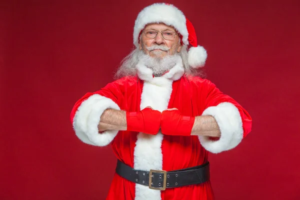 Weihnachten. Weihnachtsmann mit roten Bandagen, die sich um seine Hände wickeln, um Tritte zu imitieren. Kickboxen, Karate, Boxen. isoliert auf rotem Hintergrund. — Stockfoto