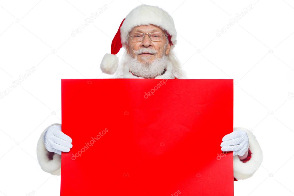 Christmas. The kind Santa Claus in white gloves holds an empty cardboard of red color. Place for advertising, for text, empty space. Copy-paste. Isolated on white background.