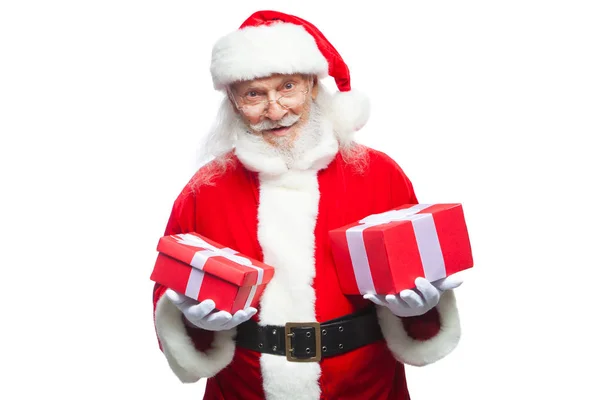 Navidad. Santa Claus sonriente con guantes blancos sostiene dos cajas con regalos. El concepto de elegir un regalo, regalos generosos. Aislado sobre fondo blanco . — Foto de Stock