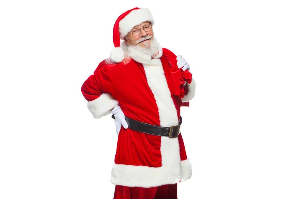 Christmas. Santa Claus is suffering from back pain and holds a red bag with gifts on his back. Isolated on white background. — Stock Photo, Image