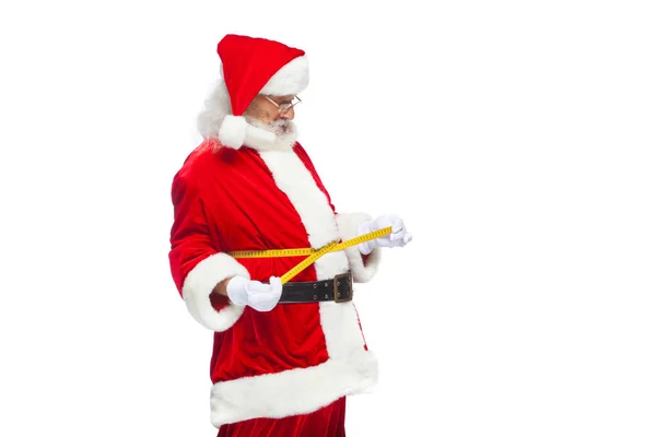 Boże Narodzenie. Święty Mikołaj jest pomiar talii z taśmy. Koncepcja odchudzania, zdrowego odżywiania. Na białym tle. — Zdjęcie stockowe