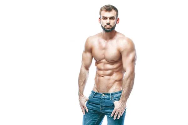 Bodybuilder posant. Beau sportif homme puissance masculine. Fitness musclé en jeans bleus. sur fond blanc isolé . — Photo